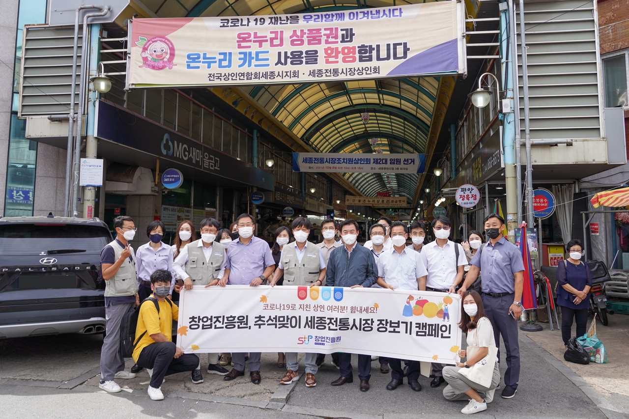 창업진흥원, 추석맞이 세종전통시장 장보기 캠페인 플랭카드를 시장입구에서 들고 창업진흥원장을 비롯한 임직원이 포즈를 취하고 있다