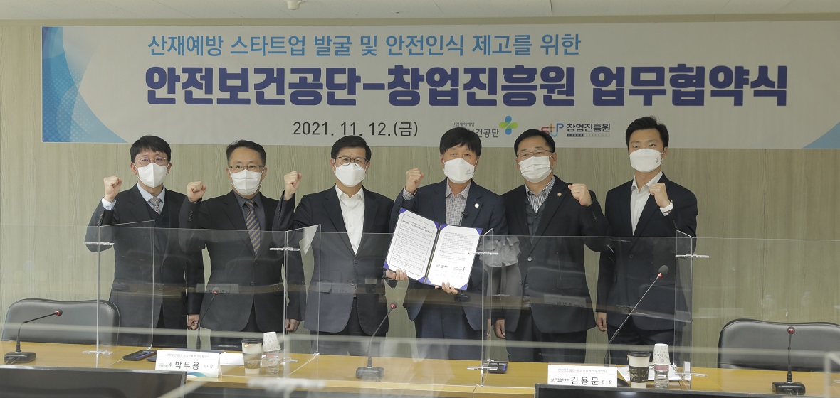 창업진흥원장이 한국산업안전보건공단 담당자들과 협약서를 들고 사진을 찍고 있음.