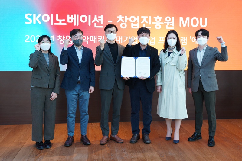 창업진흥원 김용문원장과 SK이노베이션 직원들이 업무 협약서를 들고 사진을 찍고 있음.