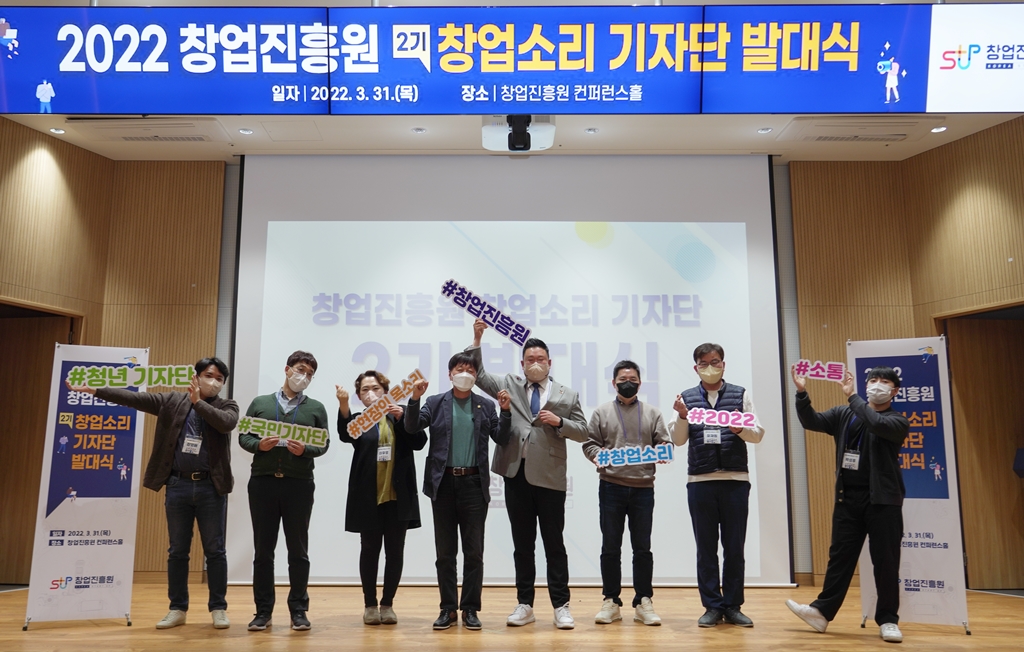 창업진흥원장과 기자단 발대식 참석자들이 각각 표어 펫말을 들고 함께 사진을 찍고 있음.